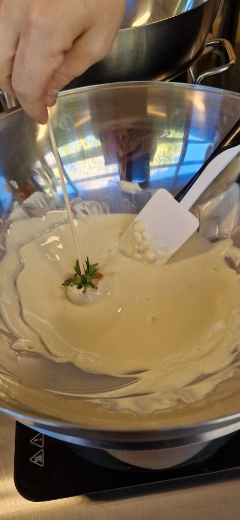 Aardbei wordt gedipt in witte chcolade
